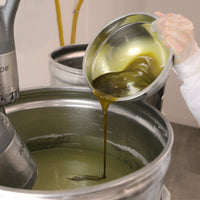 L'huile de baies de laurier ajoutée après saponification accompagnée de l'argile verte pour créer notre savon saponifié à froid certifié bio pour les peaux à imperfection et acnéiques